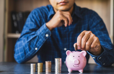 Businessman holding coins putting in a piggy bank. concept of saving money for finance accounting,...