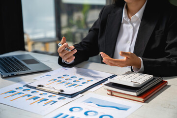 business woman using laptop analyzing graph document showing investment results and the operating results of the company