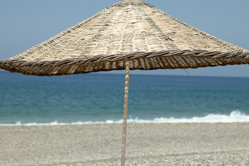 Wooden braided umbrella on the beach.