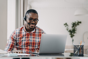 African american male student wearing headset learn language online at laptop. Distance education