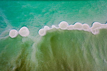 Israeli coast of the Dead Sea. salt mushroom  crystals formations, clear cyan green calm water...