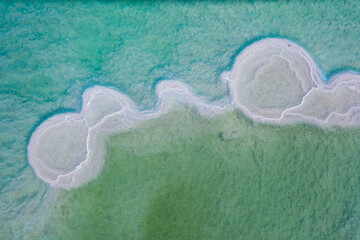 Israeli coast of the Dead Sea. salt mushroom  crystals formations, clear cyan green calm water...