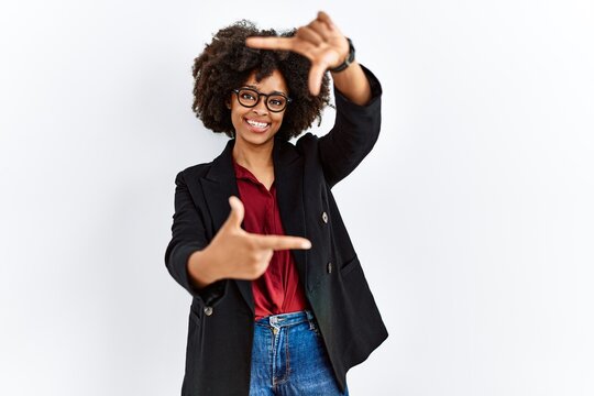 African american woman with afro hair wearing business jacket and glasses smiling making frame with hands and fingers with happy face. creativity and photography concept.