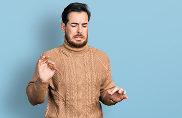 Young hispanic man wearing casual clothes disgusted expression, displeased and fearful doing...