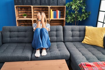 Young blonde woman depressed sitting on sofa at home