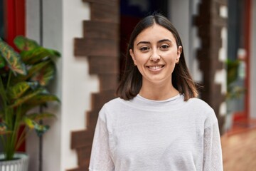 Fototapeta premium Young hispanic woman smiling confident standing at street