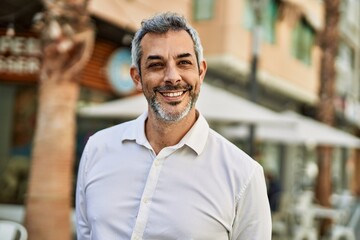 Obraz premium Middle age grey-haired man smiling happy standing at the city.