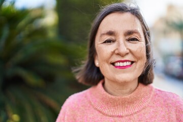 Middle age woman smiling confident standing at park