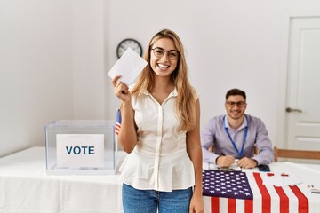 Young american voter woman smiling happy holding vote at electoral college.