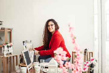 enterprising latin american young woman tidying up her workplace and looking at camera.