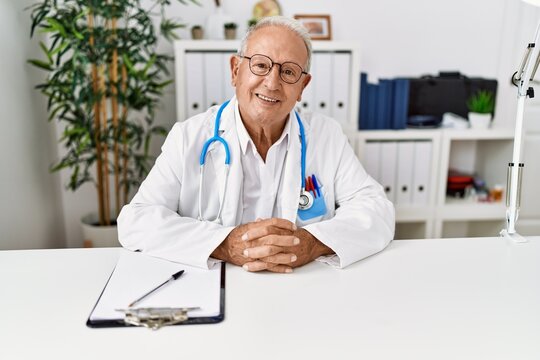 Senior man wearing doctor uniform working at clinic