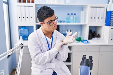 Down syndrome man wearing scientist uniform and gloves at laboratory