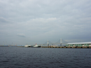 Fototapeta na wymiar Tokyo bay. Yokohama Bay Bridge in background. Cloudy sky over sea