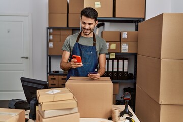 Young hispanic man business worker using smartphone and credit card at storehouse