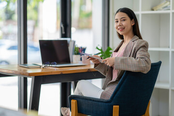 Young adult Asian women work at home or modern office, using a notebook laptop computer. Work from home life, information technology, domestic lifestyle, or self-isolation working concept