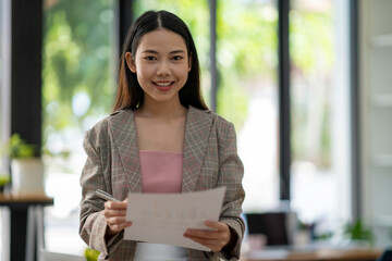 excited business woman reading good news in paper letter She was promoted and received an additional yearly bonus.