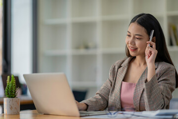 Portrait of freelance smart business women casual wear using tablet working in workplace in living room at home. Happy young Asian girl relax sitting on desk search and do job in internet.