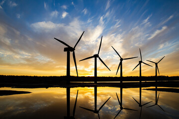 Windmills in water. Wind farm next to river. Windmills before sunset. Green energy. Windmills in...