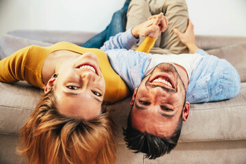Couple in love lying on sofa at home - Boyfriend and girlfriend having fun together on bedroom