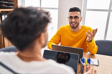Two man business workers using laptop speaking at office