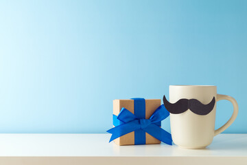 Coffee cup with mustache and gift box on white table over blue background. Happy Father's day...
