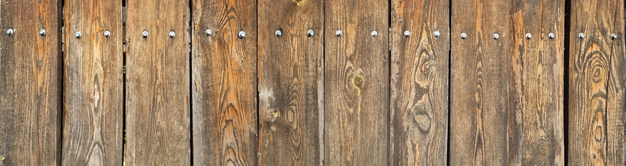 Obraz premium Monumental fence made of natural wooden planks, fragment. horizontal composition. The texture of the annual stripes of a tree. Image for the background. selective focus