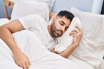 Obraz na płótnie Canvas Young hispanic man sleeping on bed at bedroom