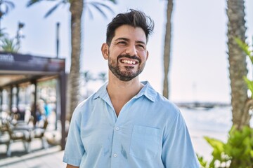 Young hispanic man smiling happy standing at the promenade.