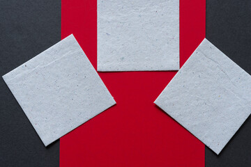 paper squares on red and gray paper