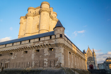Fototapeta na wymiar Donjon médiéval éclairé par le soleil en fin de journée et ses remparts