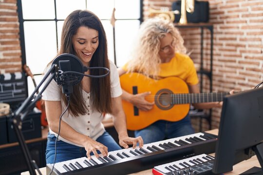 Two Women Musicians Singing Song Playing Classical Guitar And Piano At Music Studio