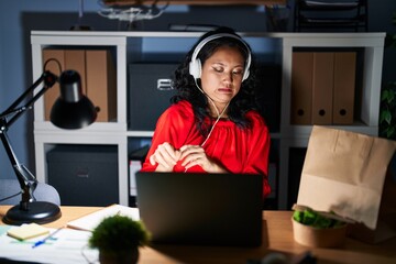 Young asian woman working at the office with laptop at night disgusted expression, displeased and...
