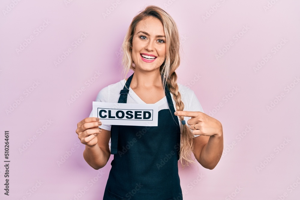 Sticker beautiful young blonde woman wearing waitress apron holding closed banner smiling happy pointing wit