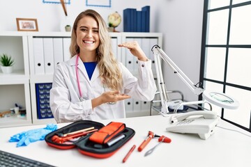 Young beautiful doctor woman with reflex hammer and medical instruments gesturing with hands...