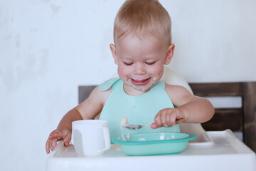 kid eats with a spoon and learns by himself