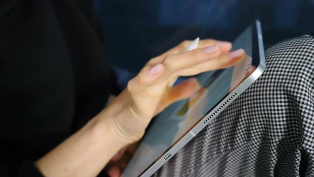 Creative graphic designer working in office on tablet using her fingers. Closeup. Architect designer working with laptop tablet, creative designer drawing and colouring while making digital