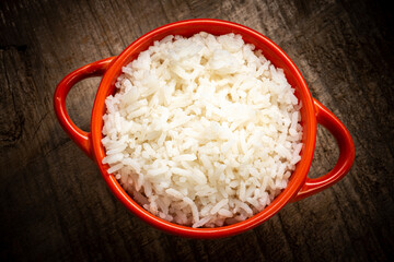 White rice served in a clay bowl on a rustic wooden table
