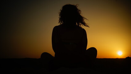 Woman's silhouette at sunset. Meditation, calmness