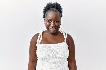 Young african woman standing over white isolated background with a happy and cool smile on face....
