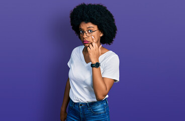 Obraz na płótnie Canvas Young african american woman wearing casual white t shirt pointing to the eye watching you gesture, suspicious expression