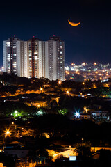 Limeira, São Paulo, Brasil: Lua crescente com a as luzes da cidade de Limeira no interior do...