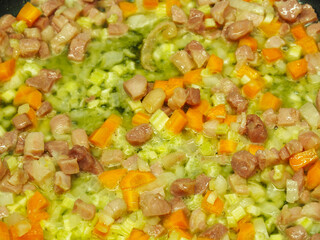 Frying pancetta bacon and vegetables close-up view