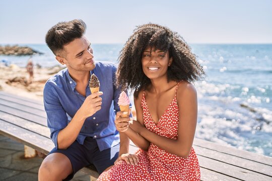 Man and woman couple smiling confident using smartphone at seaside