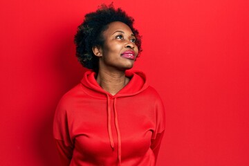 Fototapeta na wymiar Young african american woman wearing casual sweatshirt smiling looking to the side and staring away thinking.