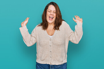 Young plus size woman wearing casual clothes celebrating mad and crazy for success with arms raised...