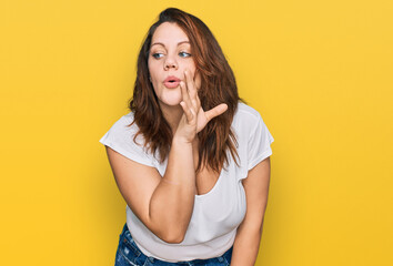 Young plus size woman wearing casual white t shirt hand on mouth telling secret rumor, whispering malicious talk conversation