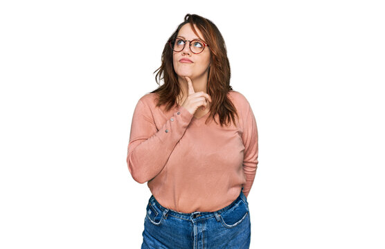 Young plus size woman wearing casual clothes and glasses thinking concentrated about doubt with finger on chin and looking up wondering
