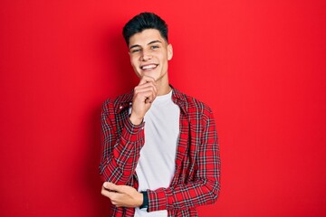 Young hispanic man wearing casual clothes looking confident at the camera with smile with crossed...