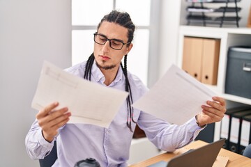 Young man business worker reading document working at office
