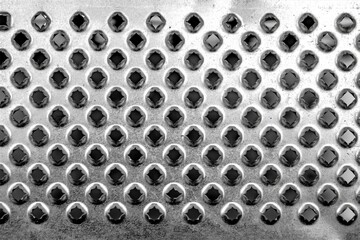 Authentic metal grater texture. Texture of an old kitchen grater. Metal geometric holes are sharp.